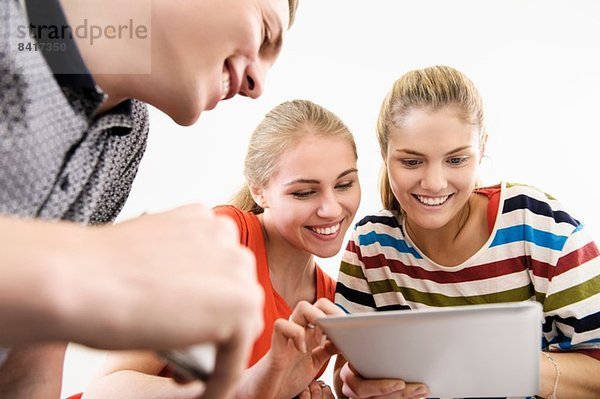 Drei junge erwachsene Freunde mit digitalem Tablett