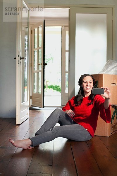 Junge Frau beim Selbstporträt im neuen Haus