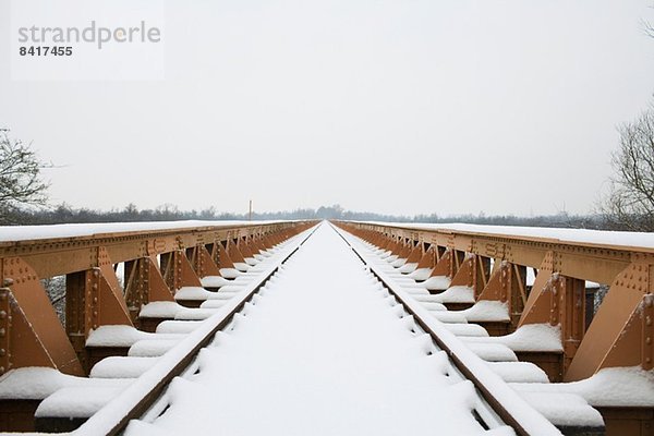 Gleis und Brücke im Winter Schnee