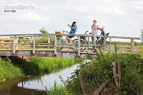 Familienradfahren über Holzbrücke