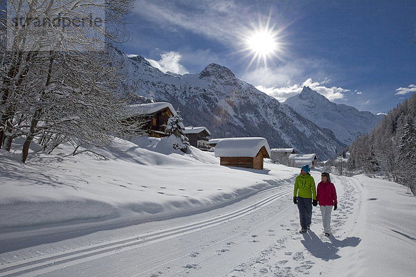 Frau Winter Mann gehen folgen Weg Dorf wandern 2 Wanderweg Schnee Wintersport