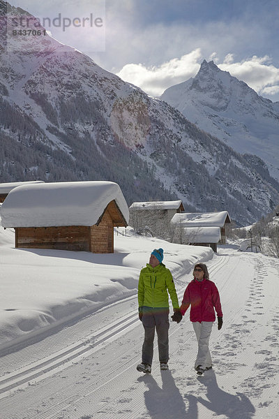 Frau Winter Mann gehen folgen Weg Dorf wandern 2 Wanderweg Schnee Wintersport
