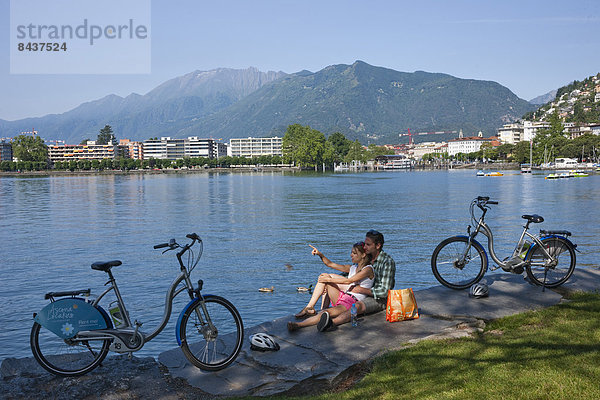Frau Mann Strand Sommer Fahrrad Rad Küste See Dorf Südschweiz Fahrrad fahren Elektrofahrrad Ebike