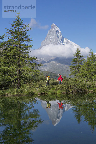 Frau Mann gehen Spiegelung See wandern Matterhorn Tanne Bergsee