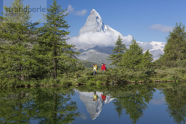 Frau Mann gehen Spiegelung See wandern Matterhorn Tanne Bergsee