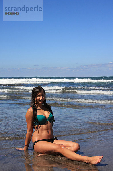 sitzend  Wasser  Jugendlicher  Europa  Frau  Strand  Bikini  Küste  braunhaarig  Kanaren  Kanarische Inseln  Mädchen  Spanien  Teneriffa