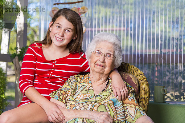 Aged woman and her great-granddaughter side by side