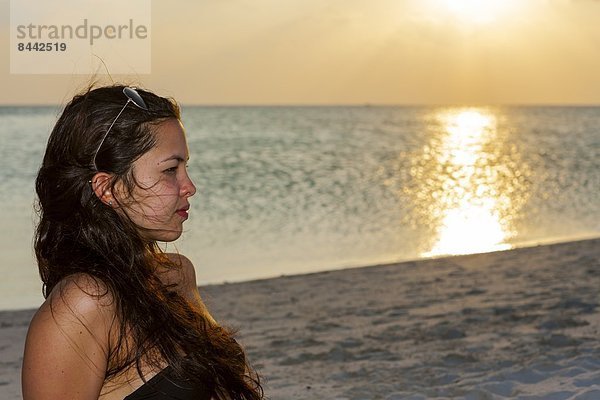 Maldives  Young woman sitting at beach