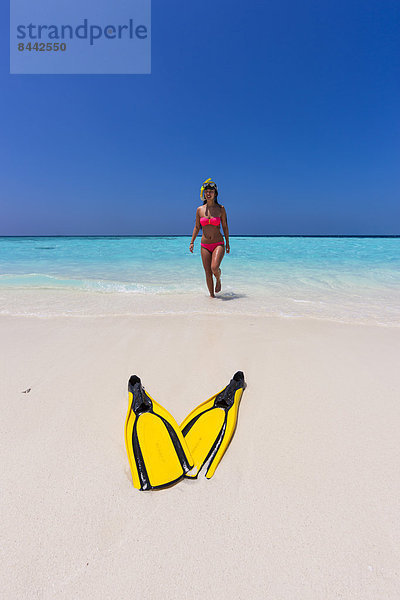 Maledives  young woman walking at beach