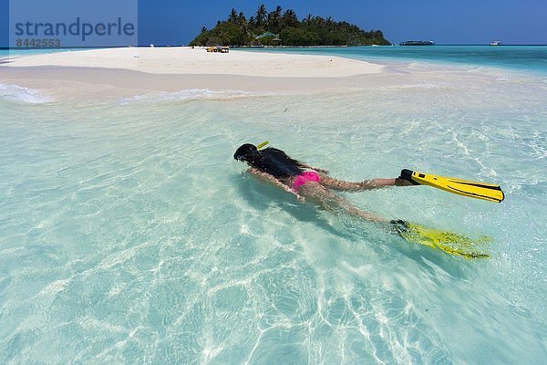 Maledives  young woman snorkelling in a lagoon