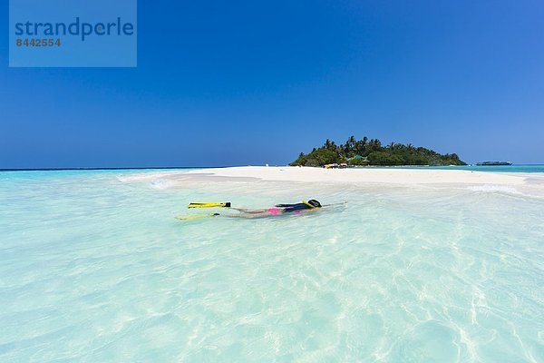 Maledives  young woman snorkelling in a lagoon