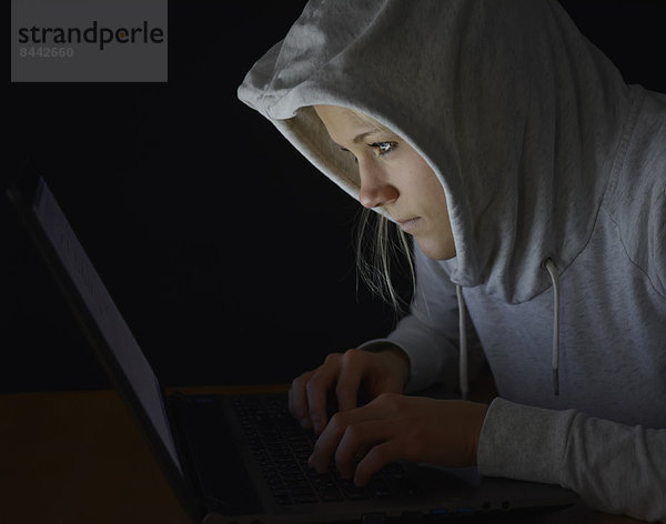 Young woman using laptop by night