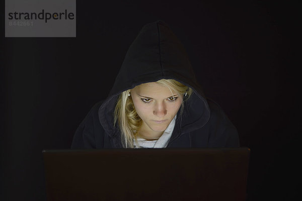 Young woman using laptop by night