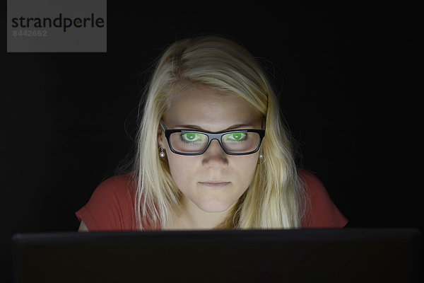 Junge Frau mit Laptop bei Nacht