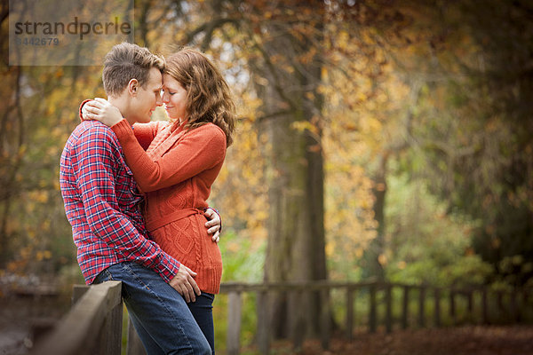 Happy young couple enjoying autumn in a park