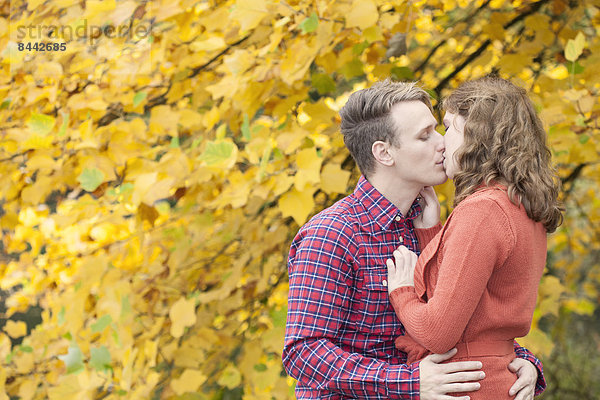 Happy young couple enjoying autumn in a park