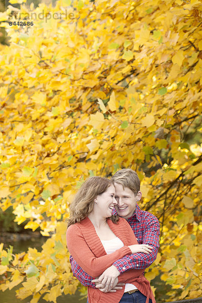 Happy young couple enjoying autumn in a park