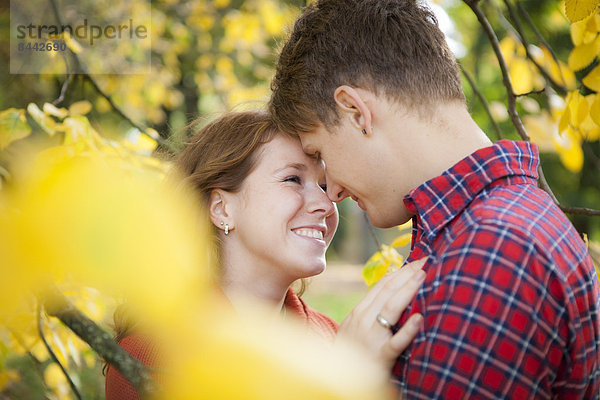 Happy young couple kissing in a park