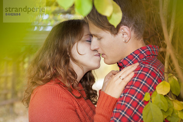 Happy young couple kissing in a park