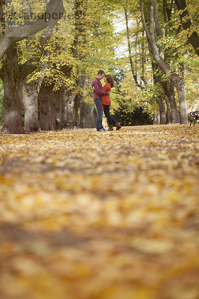 Happy young couple enjoying autumn in a park