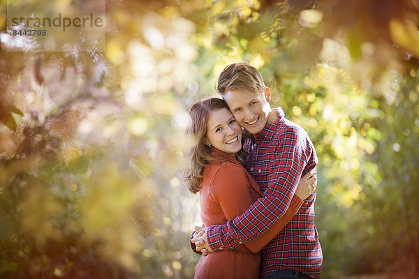 Happy young couple enjoying autumn in a park