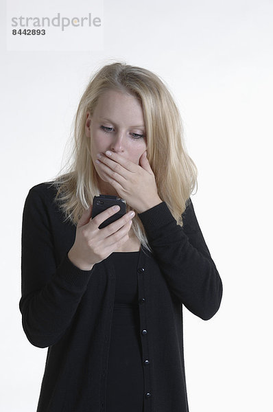 Schockierte junge Frau beim Anblick des Smartphones