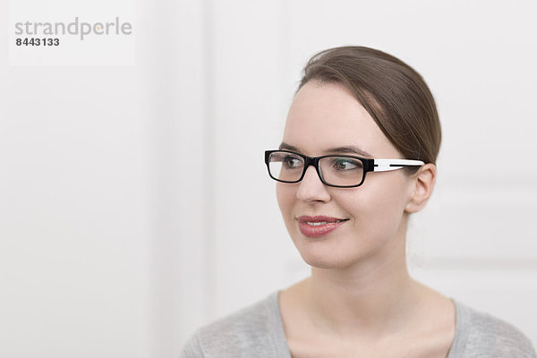 Junge Frau mit Brille denkend