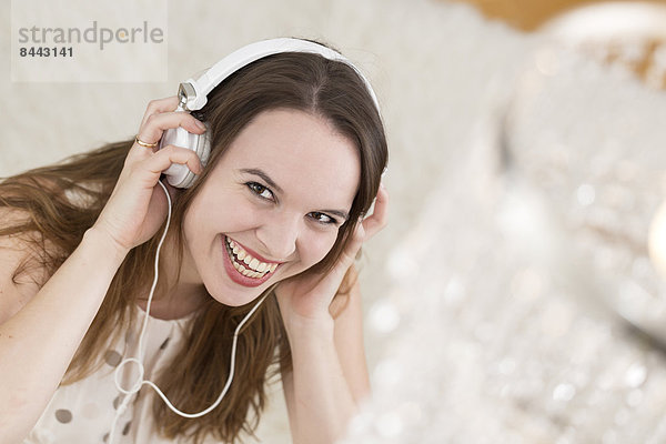 Lachende junge Frau mit Kopfhörer