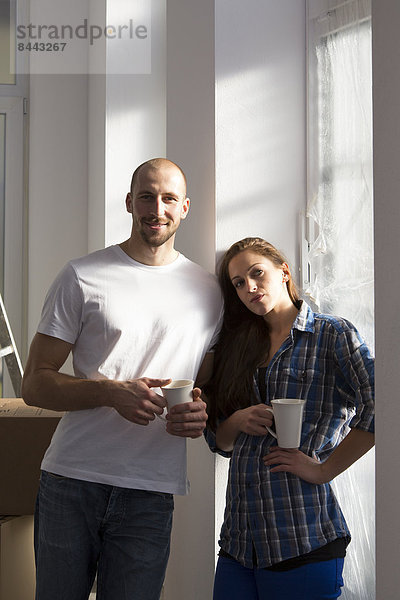 Young couple moving into new home  taking a coffee break