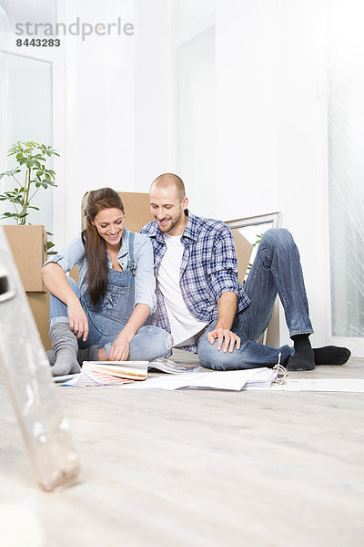Young couple moving into new home  looking at color sample