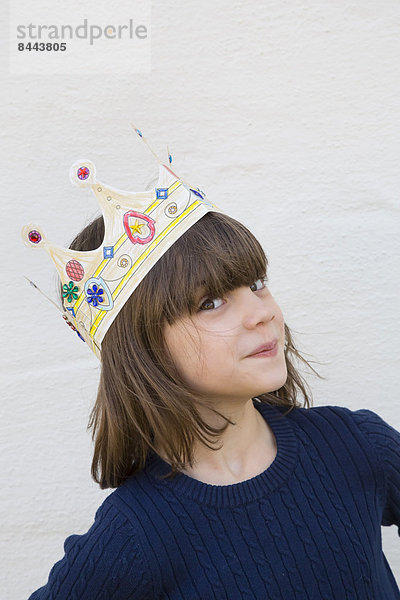 Porträt des kleinen Mädchens mit Papierkrone auf dem Kopf