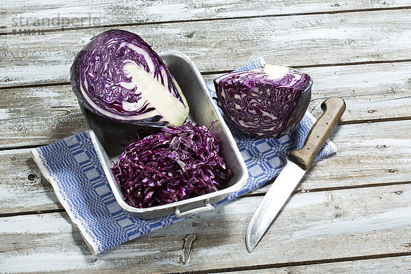 Red cabbage  kitchen knife and kitchen towel on wooden table