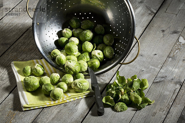 Brussel sprout in colander  kitchen towel on wooden table