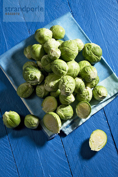 Brussel sprout on kitchen towel  knife on blue wooden table