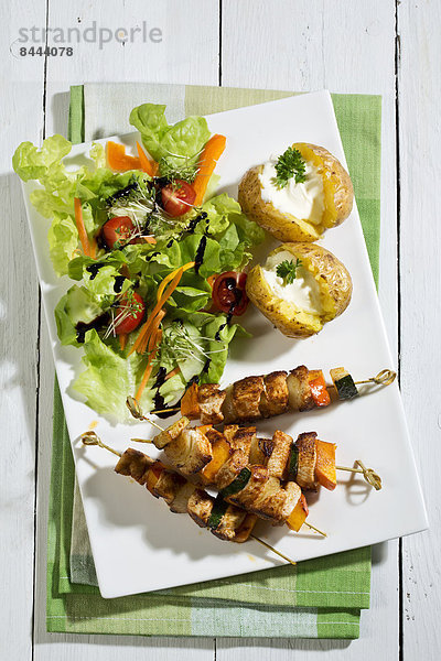 Chicken meat sticks with baked potatoes and mixed salad