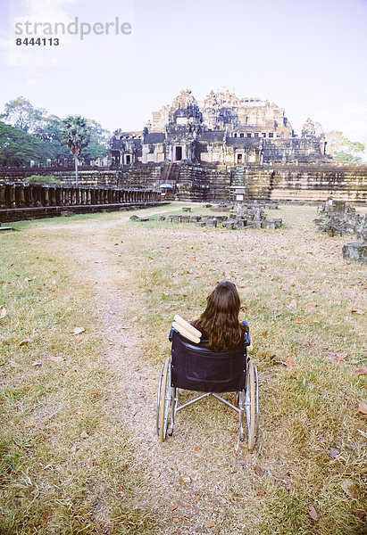 Kambodscha  Siem Reap  Angkor  Behinderter Tourist im Rollstuhl vor Angkor Wat