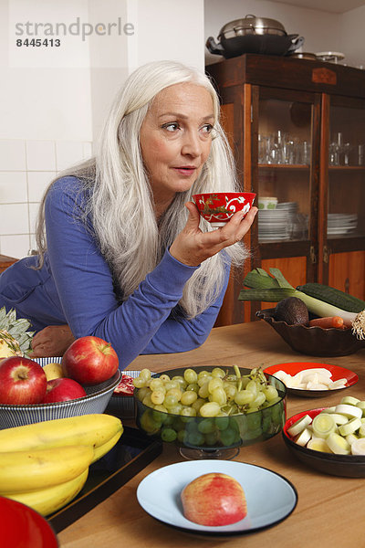 Senior woman with raw food drinking tea