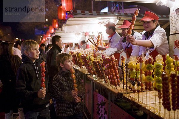 Blumenmarkt  Glasierter Apfel  Glasierte Äpfel  kandierter  Liebesapfel  Junge - Person  Nacht  Erdbeere  Peking  Hauptstadt  China  Markt