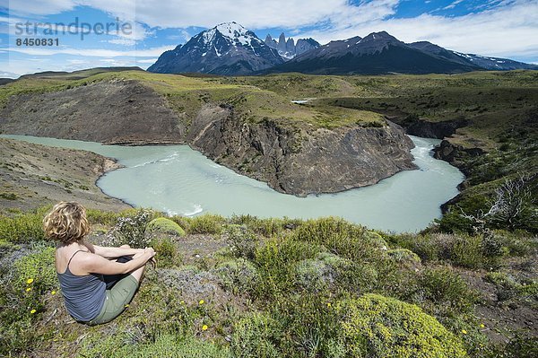 sitzend  Biegung  Biegungen  Kurve  Kurven  gewölbt  Bogen  gebogen  Frau  über  Fluss  frontal  Chile  Patagonien  Südamerika