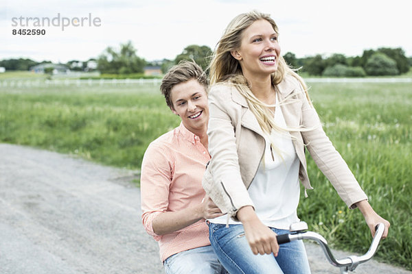 Glückliches junges Paar genießt Fahrradtour auf dem Land