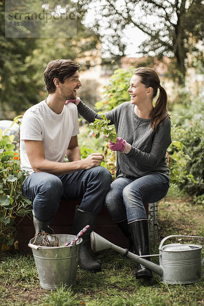 Volle Länge von glücklichen Freunden  die ihre Freizeit mit Gartenarbeit verbringen.