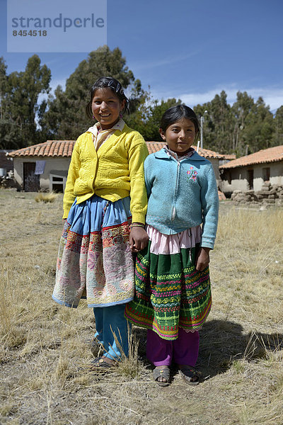 Zwei Schülerinnen der Grundschule  in traditionellen bunten Kleidern der Quechua  Union Potrero  Quispillacta  Ayacucho  Peru