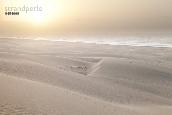 Sonne im Dunst des Meeres über der Dünenlandschaft am Strand Praia de Chaves  an der Westküste der Insel Boa Vista  Kapverden