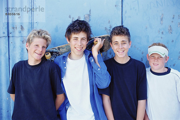 Vier kleine Jungen in einer Reihe  Freunde skateboarden.