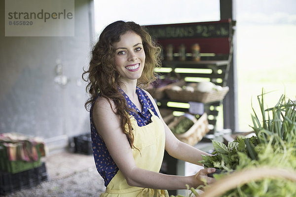 Ein ökologischer Bauernstand. Eine Frau sortiert Gemüse.