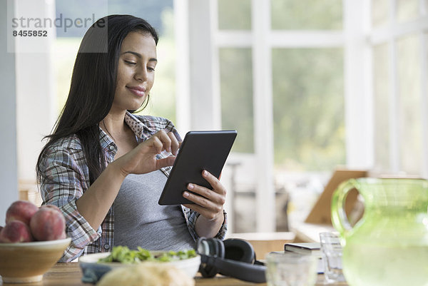 Eine Frau sitzt mit einem digitalen Tablett.
