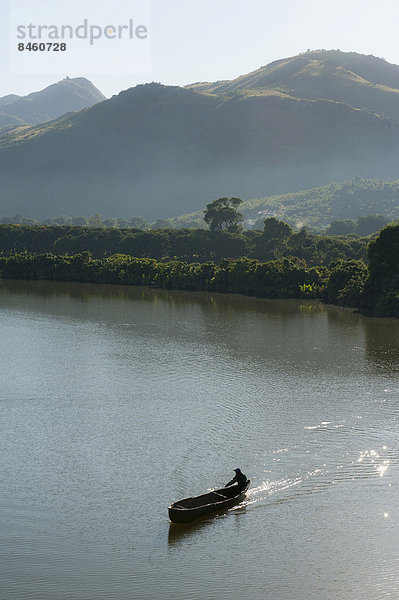 Mann in Ruderboot  Einbaum auf Fluss am Morgen  bei Fort-Dauphin oder Tolagnaro  Madagaskar