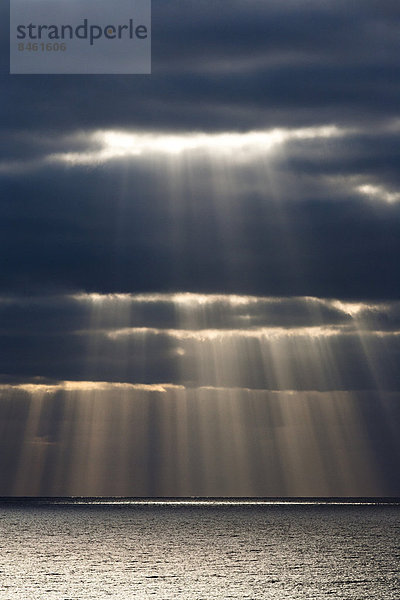 Sonnenstrahlen scheinen durch dunkle Gewitterwolken  Fuerteventura  Kanarische Inseln  Spanien