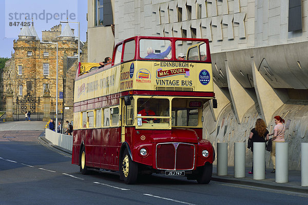 Touristenbus vor dem modernen Schottischen Parlament und dem Palast Holyrood Palace  Edinburgh  Schottland  Großbritannien