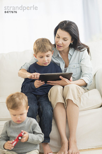 Mother and sons (12-17 months  6-7) with tablet pc